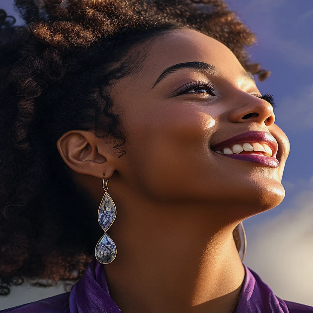 A woman smiling as she looks up into evening light.
